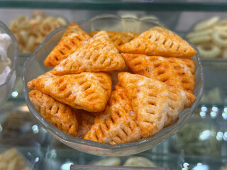 A bowl of triangular shaped snacks sits on a counter