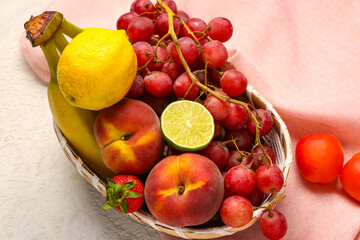 Wicker bowl with different fresh fruits on white background