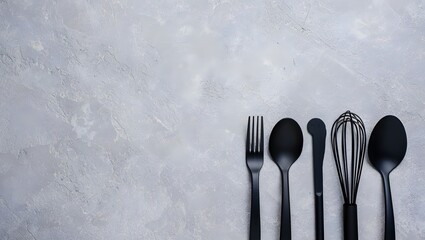 Black kitchen utensils flat lay on concrete background for cooking and food photography