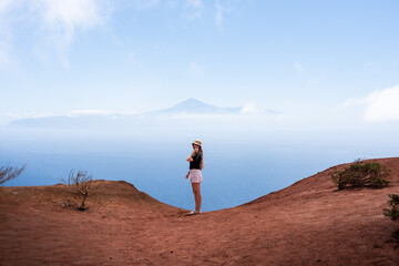 Tourist enjoying breathtaking view of el Teide from red mountain of la Gomera, canary islands