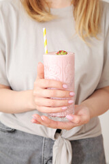 Woman holding glass of tasty strawberry smoothie on white background