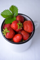 Cup filled with fresh strawberries. Seasonal summer berries, healthy dessert or snack.