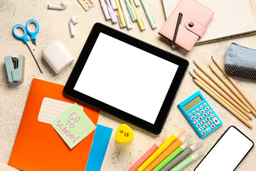 Sticky note with text GO TO SCHOOL, gadgets and different stationery on grunge white background