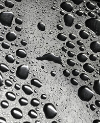 A detailed closeup view showcasing water droplets on a blue surface