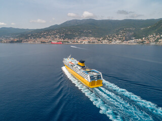 Big yellow passenger ferry goes on the Mediterranean Sea near Corsica island, France aerial view...