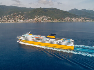 Big yellow passenger ferry goes on the Mediterranean Sea near Corsica island, France aerial view...