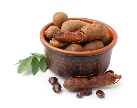 Bowl of tasty tamarinds and leaf on white background