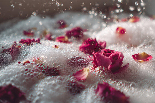 Romantic Rose Petal Bath Scene. Rose petals on foamy bubbles in a bath create a calming and romantic atmosphere, perfect for spa or relaxation themes.