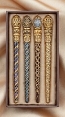 Four Ornate Decorative Wands in a Brown Gift Box on Gold Fabric