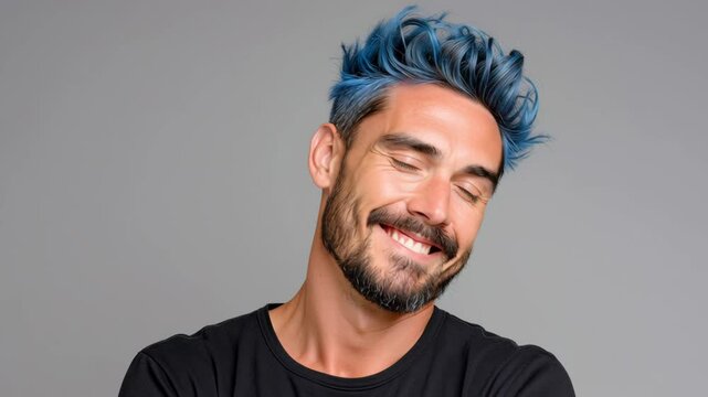 Man with blue hair and a beard is smiling for the camera. He is wearing a black shirt and he is confident and happy