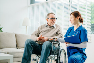 A professional nurse in blue uniform consults with a senior wheelchair patient at home, showcasing real people, empathy, and quality medical care