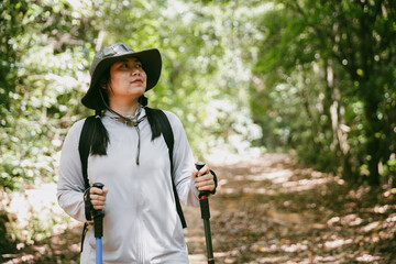 Young female traveler with backpack walking in national park or forest. recreation sport in nature....
