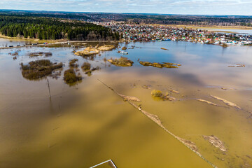 Bird's eye view of flooded floodplain fields in rural area during spring flood