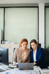 Businesswoman leading team meeting and using tablet and laptop computer with financial