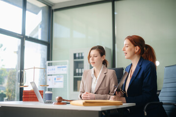 Professional female lawyers consulting on legal cases in a modern office. Perfect for law, business, justice