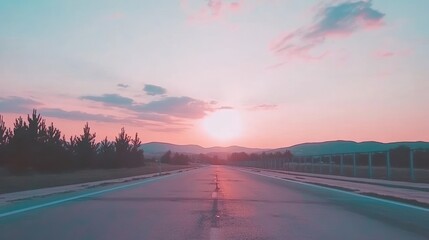 Pink Sunset Highway: Empty Road Leading to Distant Mountains
