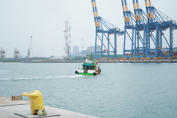 Small Tugboat Navigating Industrial Port Waters