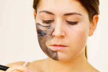 Woman being apply black carbo mask to face