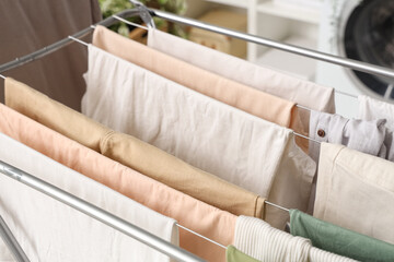 Dryer with clean clothes in laundry room, closeup