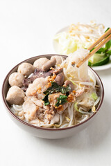 Thai noodles soup with sliced pork, minced pork, meatball and liver in a bowl eating with fresh...