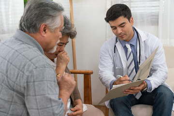 Doctor man explaining health examination results with Asian couple elderly patient at home visit. Retirement health care and life insurance concept