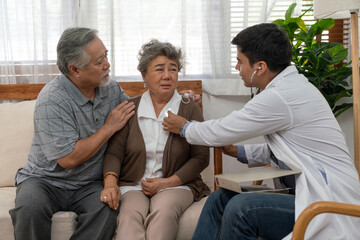 Doctor man health checkup with Asian couple elderly patient at home visit. Retirement health care and life insurance concept