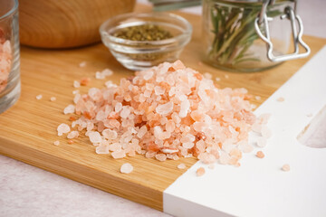 Board with Himalayan pink salt on white background