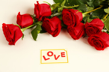 Red roses with love postcard on white background. Valentine's day concept