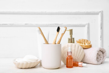 Set of different bath supplies with wooden toothbrushes on light table