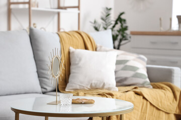 Golden mirror on table in stylish living room, closeup