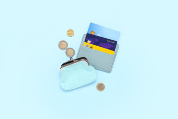 Composition with blue credit holder, cards, purse and coins on blue background