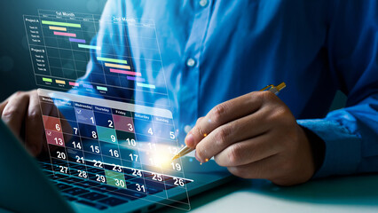 Businessman sitting with laptop on work calendar, Planning and Scheduling Calendar of meetings, events and activities Time management Notifications and reminders of important events.