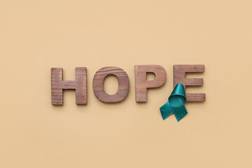 Teal ribbon and word HOPE on brown background. Sexual Assault Awareness Month
