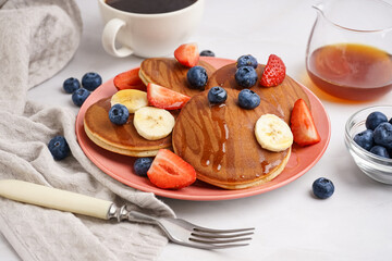 Stack of tasty pancakes with blueberries and banana on white background