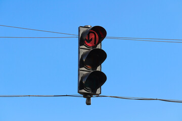 Red traffic light for U-turn suspended with wires. No U-turn signal.