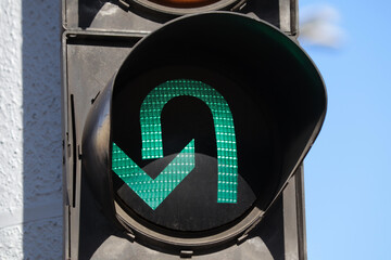 Close-up of a traffic light green arrow allowing U-turn.