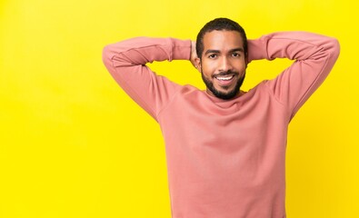Young latin man isolated on yellow background laughing