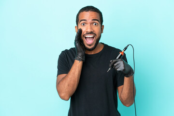 Tattoo artist Ecuadorian man isolated on blue background with surprise and shocked facial expression