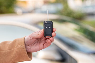 Young blonde woman holding car keys at outdoors