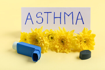 Modern inhaler with chrysanthemum flowers and word ASTHMA on yellow background