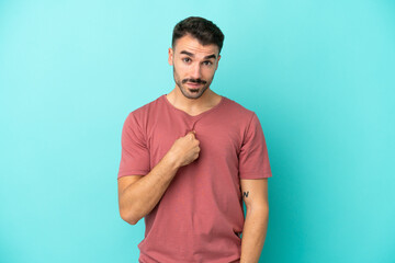 Young caucasian man isolated on blue background with surprise facial expression