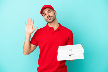 Delivery caucasian man picking up pizza boxes isolated on blue background saluting with hand with...