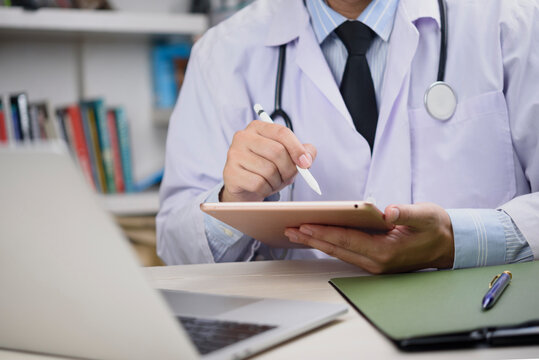 Physician hands holding digital tablet, close-up, working with laptop, medical data, modern hospital, professional healthcare, secure messaging, health information, electronic records. - Powered by Adobe