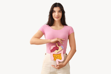 Young woman with paper digestive system on white background