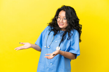 Young surgeon doctor asian woman isolated on yellow background with surprise facial expression
