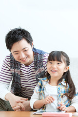 リビングをタブレットを見る親子
