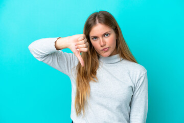 Young blonde woman isolated on blue background showing thumb down with negative expression