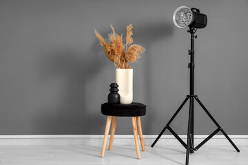 Modern photo studio with floral decor in vase and professional lightening equipment