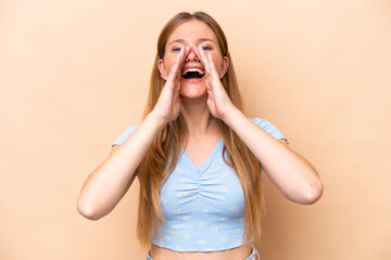 Young caucasian woman isolated on beige background shouting and announcing something