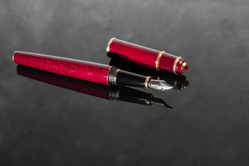 Fountain pen with box on dark gray background. Stationery branded items